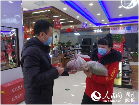 駐企聯絡員給商家送防疫中藥。謝麗娜 攝