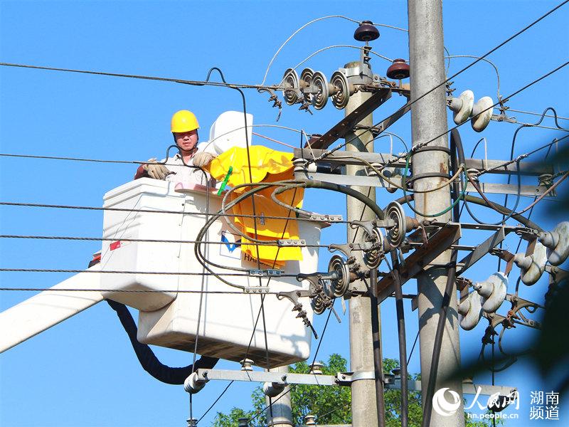 8月4日，國網常德供電公司員工在烈日下進行帶電解搭頭作業。袁晉蓉攝