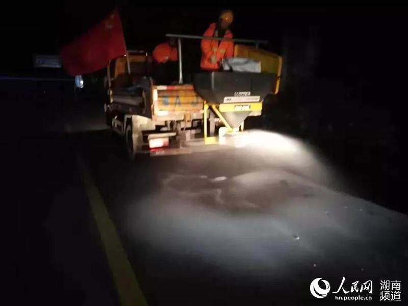 公路養護人員撒布融雪劑。湖南省公路事務中心供圖