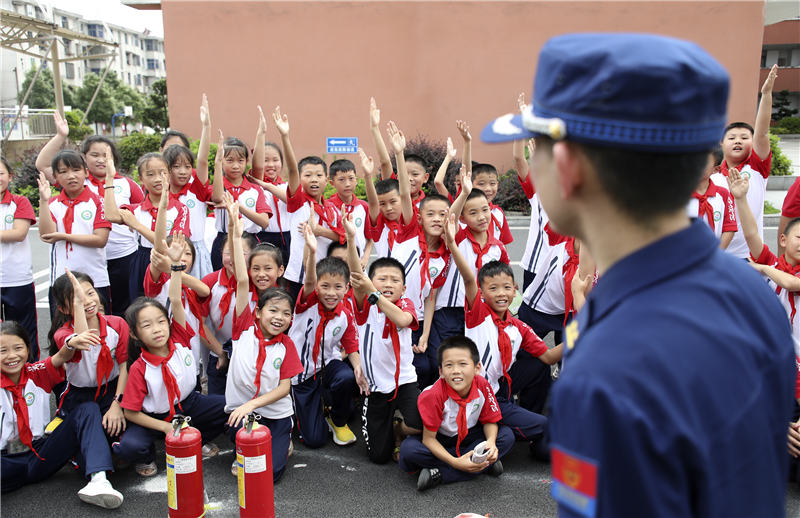 学生踊跃举手参加消防主题有奖竞答。聂亮摄