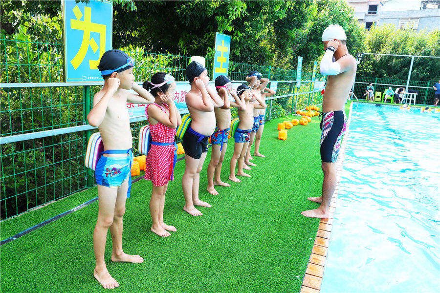  孩子们在防溺水志愿者的指导下学习游泳和防溺水技能。陈祉凝摄