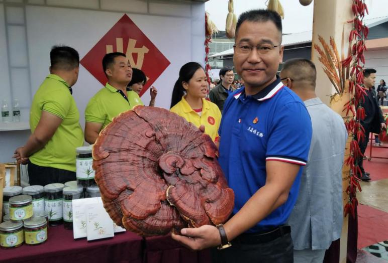 项目负责人展示着自己培植的灵芝。单位供图