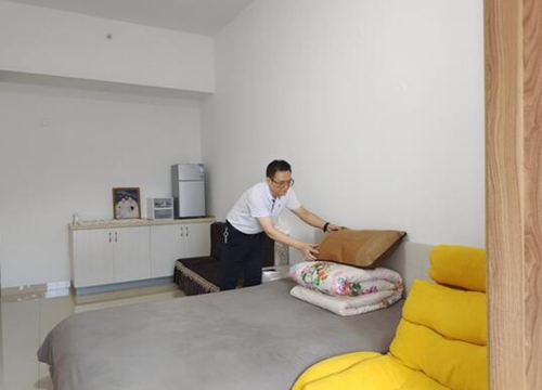 王拥军正在认真整理自己的床铺。吴涛摄