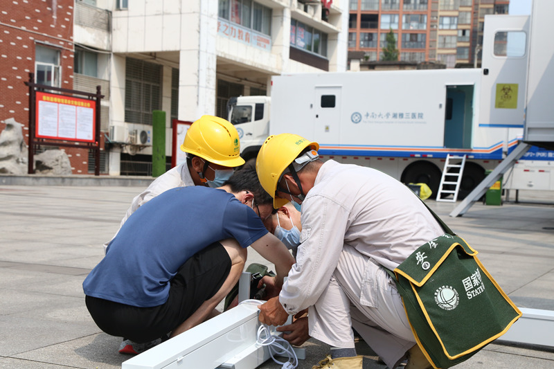 國網張家界供電公司共產黨員服務隊和實驗室工作人員一起，在安裝紫外線消毒車。唐匯剛攝