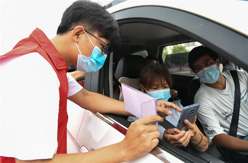 8月10日，在湖南省常寧市新河鎮湘江大橋疫情防控服務點，志願者在幫助查驗往來車輛人員健康碼、行程碼。