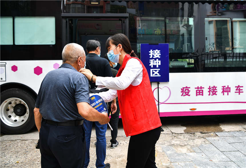 8月10日，在湖南省常寧市培元街道桃江社區，志願者引導市民有序登上流動疫苗接種車接種疫苗。周秀魚春攝