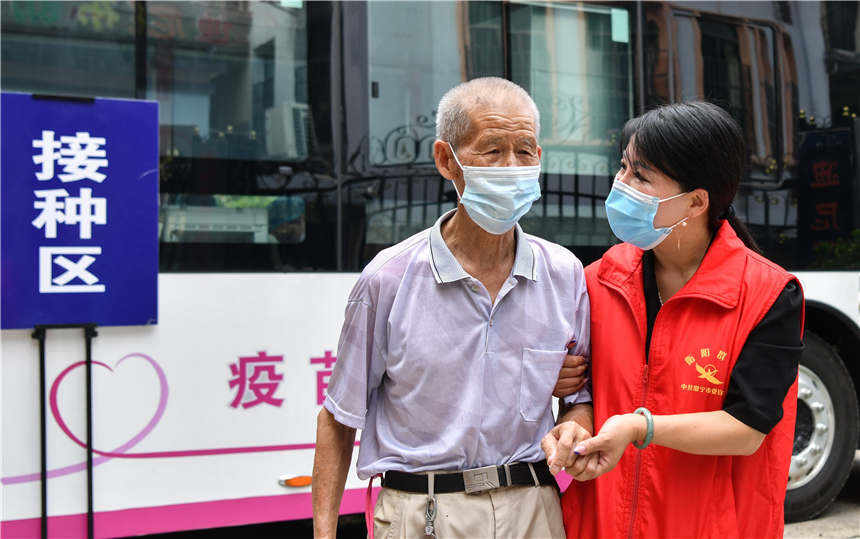 8月10日，在湖南省常寧市培元街道桃江社區，志願者為市民接種疫苗提供幫助。周秀魚春攝