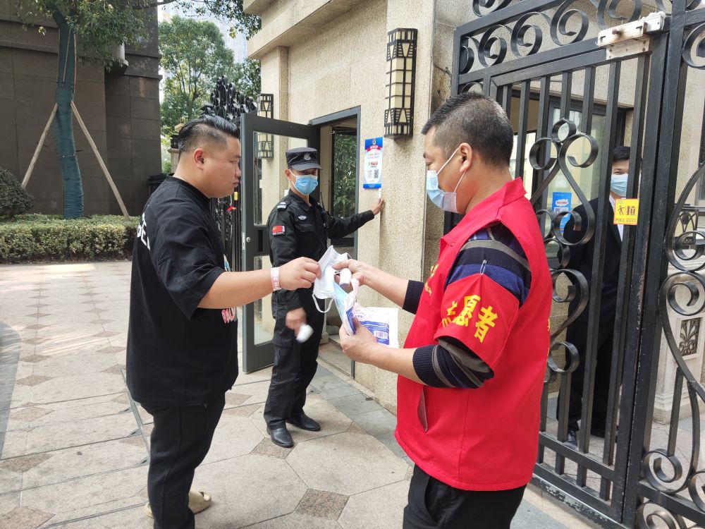 大塘沖社區7號網格黨員志願者高建設值守小區出入口，提醒居民佩戴口罩。湘龍街道供圖。
