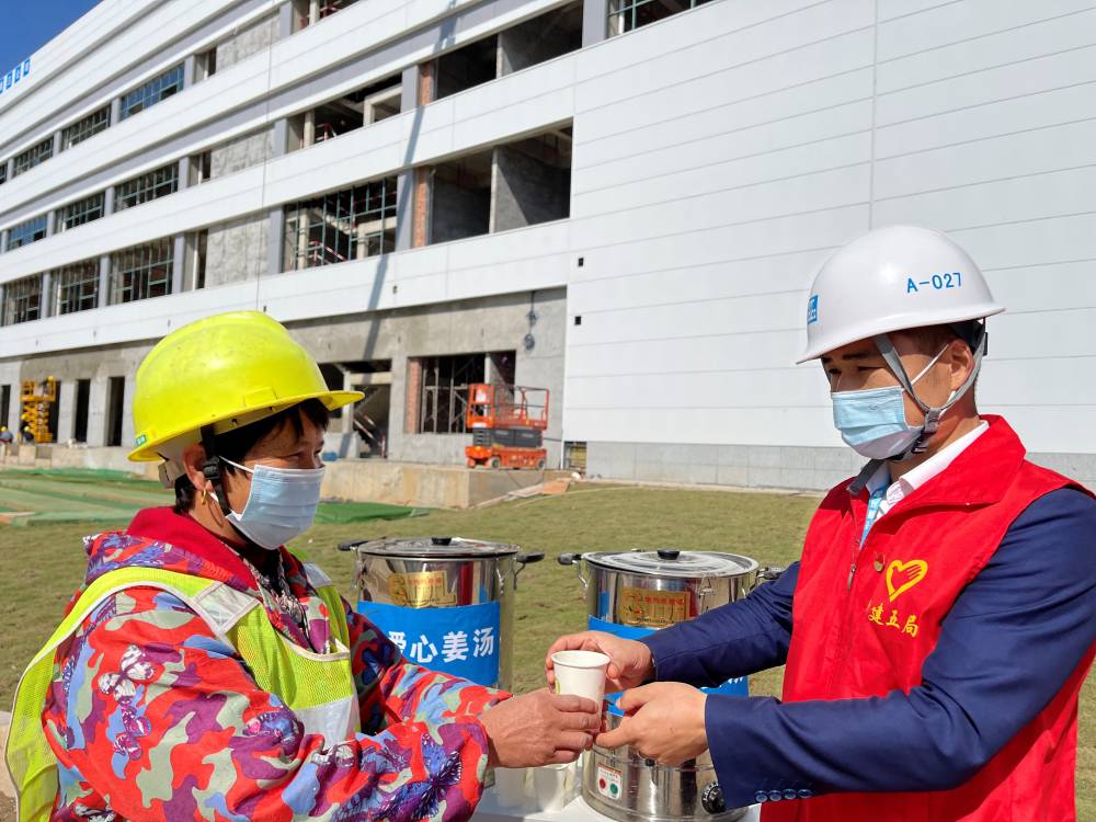 志願者為一線作業人員遞上一杯暖暖的姜湯。單位供圖