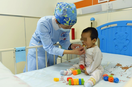 临时妈妈、湖南省儿童医院心胸外科护士长杨贵红给萱萱喂面包。姚家琦摄