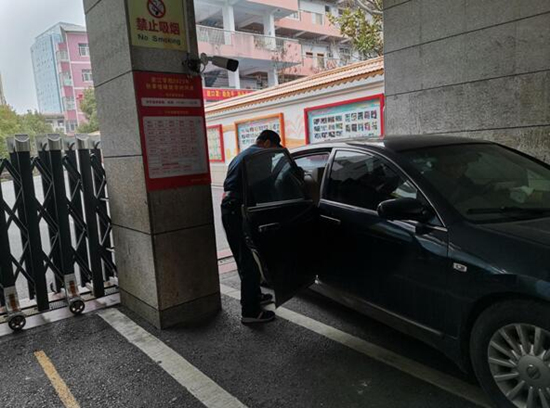 邵阳资江小学保安员张遵伟上前查看受损车辆。受访单位供图