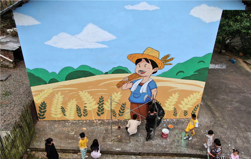 5月7日，在湖南省資興市唐洞街道高牌村，大學生志願者在創作牆體繪畫。李科攝