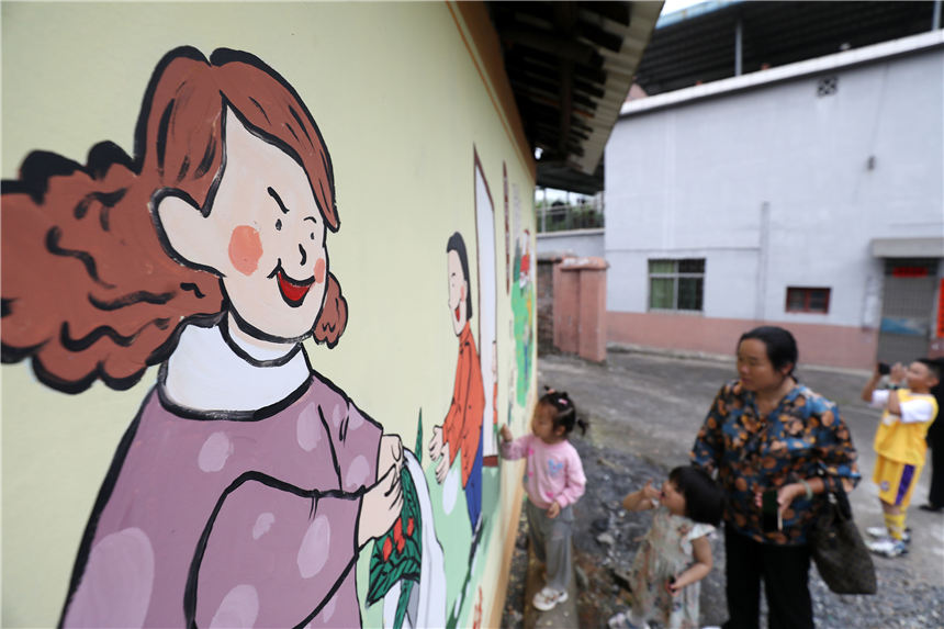 村民、小朋友在欣賞牆體繪畫。李鐵南攝