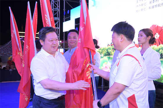 _湘潭市委书记刘志仁向“周游三湘 嗨够湘潭”暑期文旅体消费季活动暨湘潭文旅体惠民一卡通推广协会授旗。方阳摄