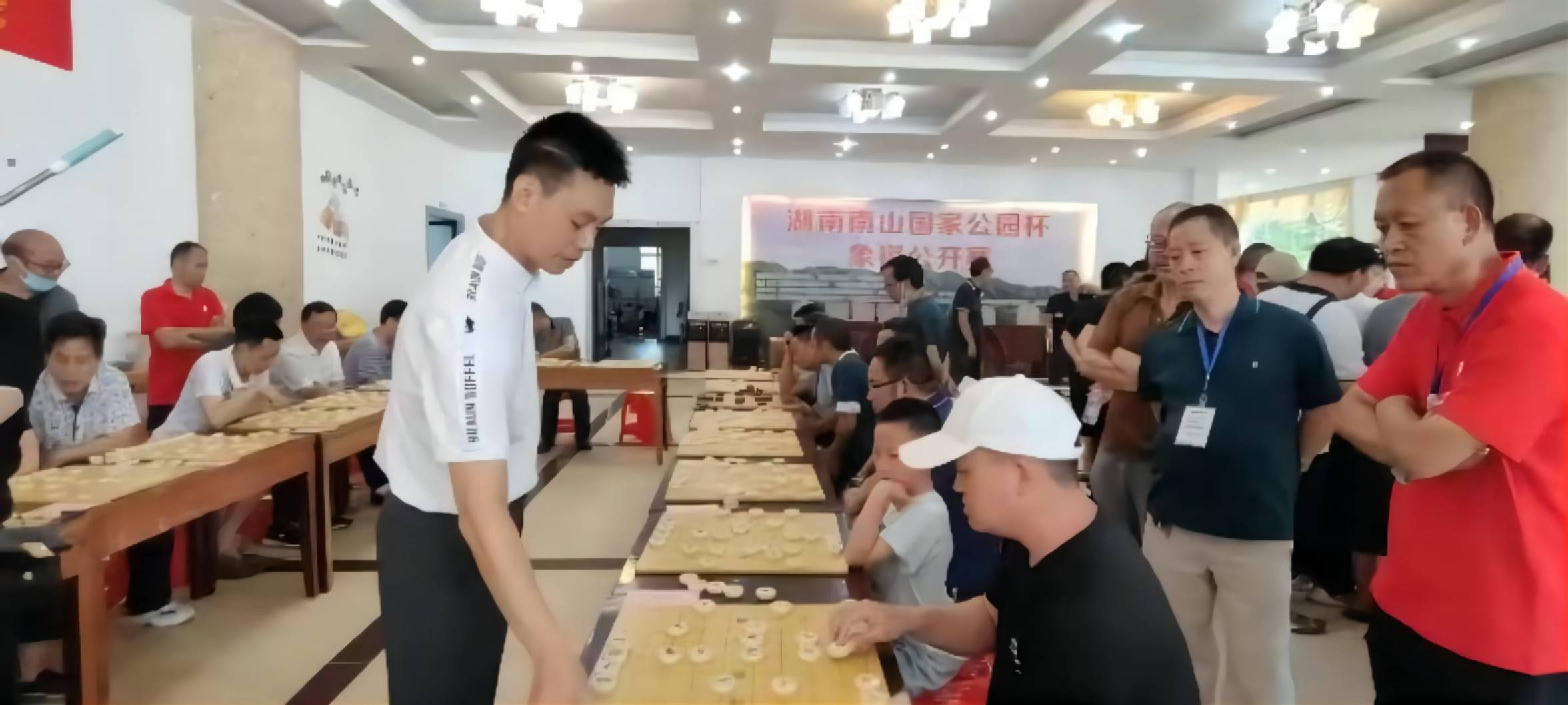 中国象棋特级大师许银川(白衣服站立者）与棋手进行车轮战。阳望春摄