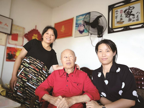 黄枚生老人（中）带动家人累计捐资3000万元助力家乡建设。 资料图片