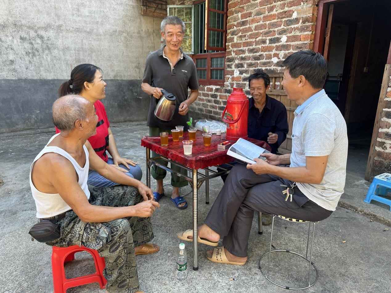 革命烈士家屬曾慶余正在給路過“紅軍路”的鄉親們沏茶。李金攝