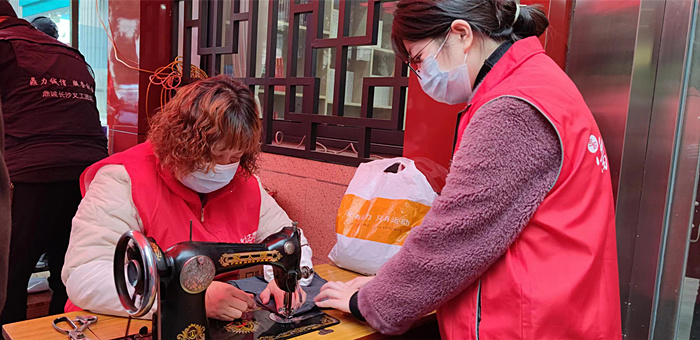 社区志愿者在红色服务站为居民提供免费缝补服务。人民网记者 刘宾摄
