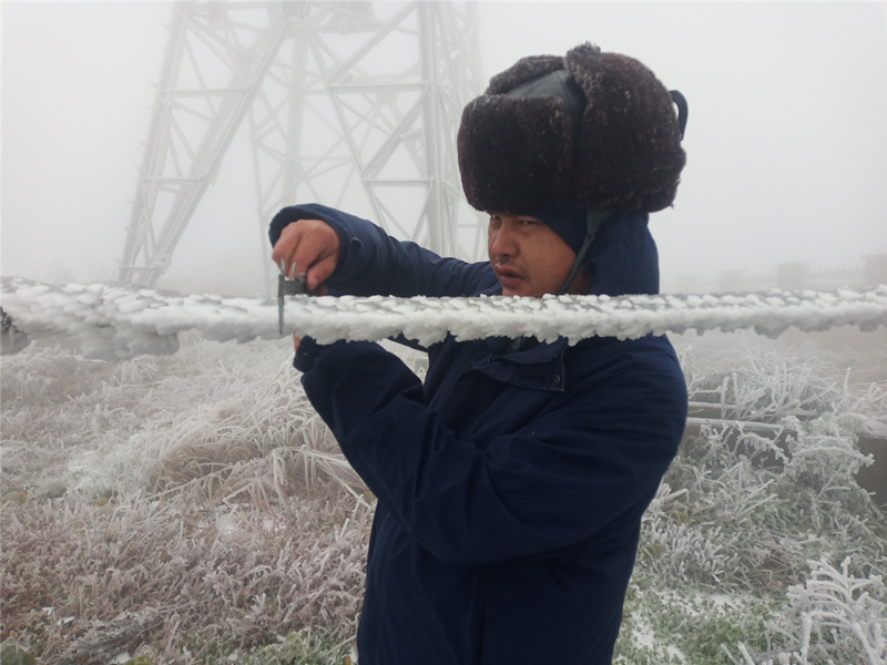 国网怀化供电公司员工在位于海拔1420米西晃山上的西公线监视哨，每4小时一次监测冰情。梁晓剑摄