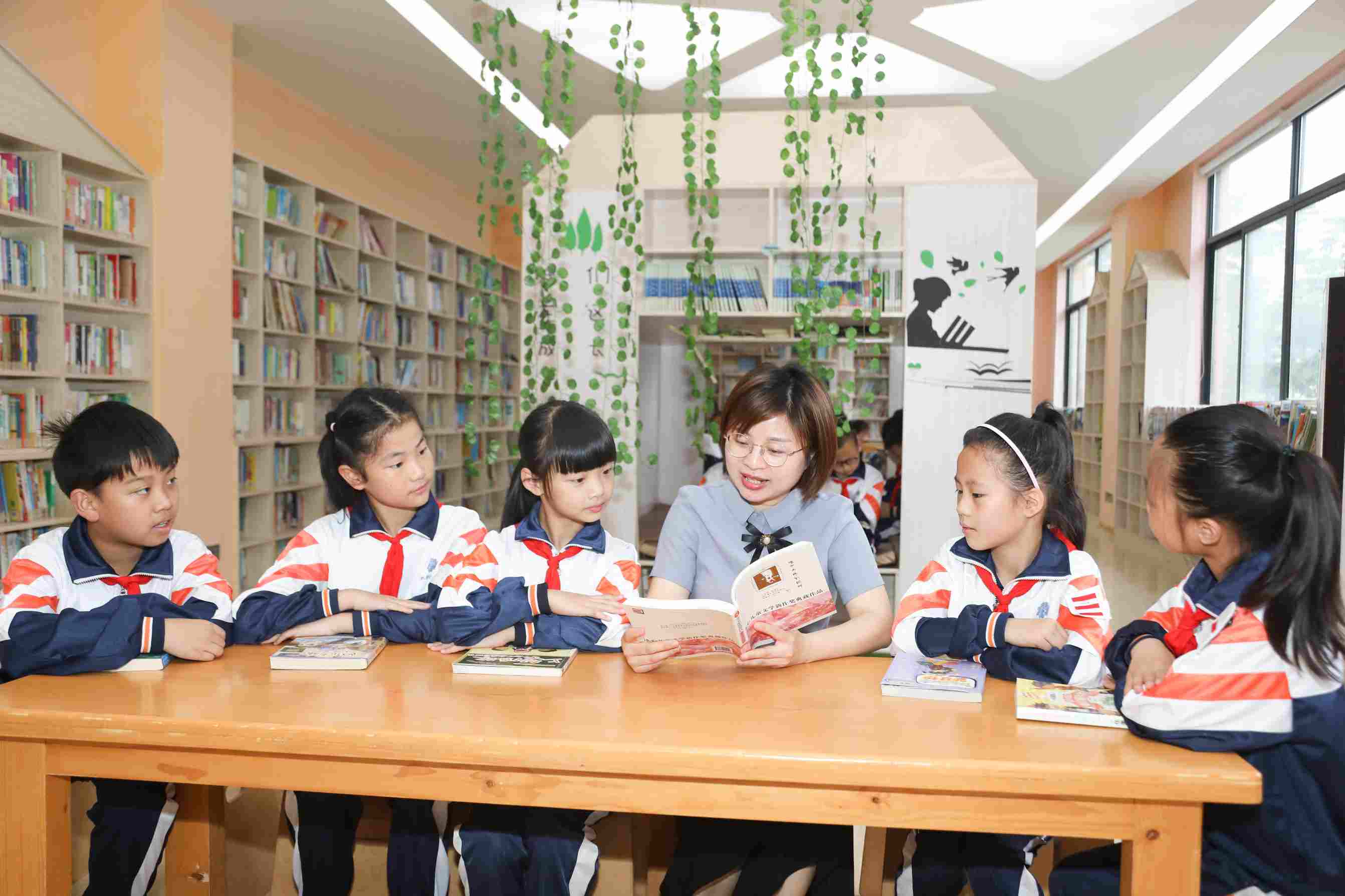 仰天湖中建小学老师与学生一起在图书馆共读一本书。仰天湖中建小学供图