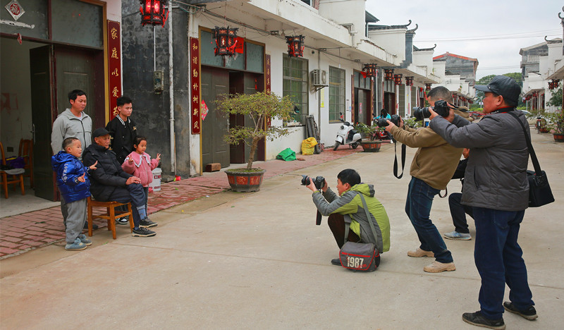 摄影师门正为村民拍摄全家福。江永县文联供图