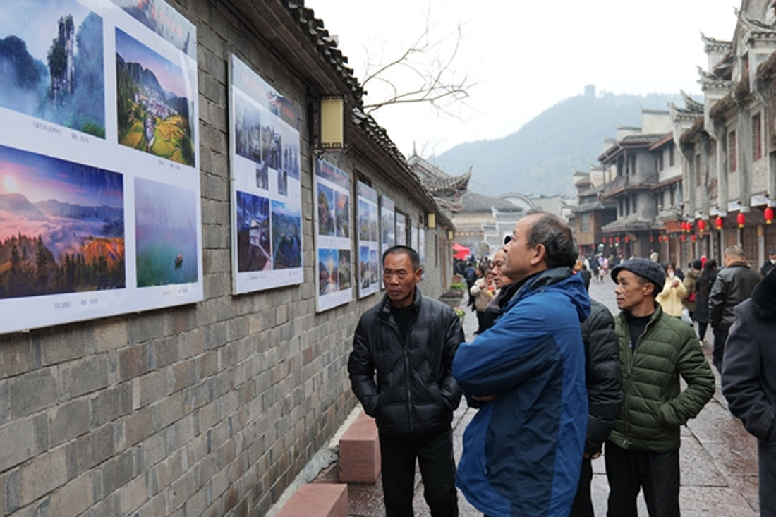 游客市民駐足欣賞迎春攝影作品展。 吳東林攝