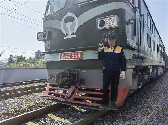 曹永勤站在列车前。受访单位供图