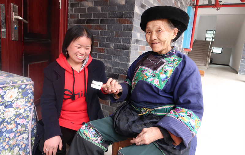 工作人員為老人戴上指夾式血氧儀。湘西州民政局供圖
