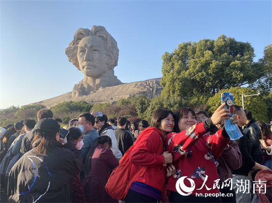 游客在巨幅青年毛泽东头像前拍照留念。 人民网 向宇摄