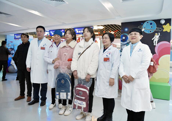 罗红、罗兰姐妹与医护人员合影。姚家琦摄