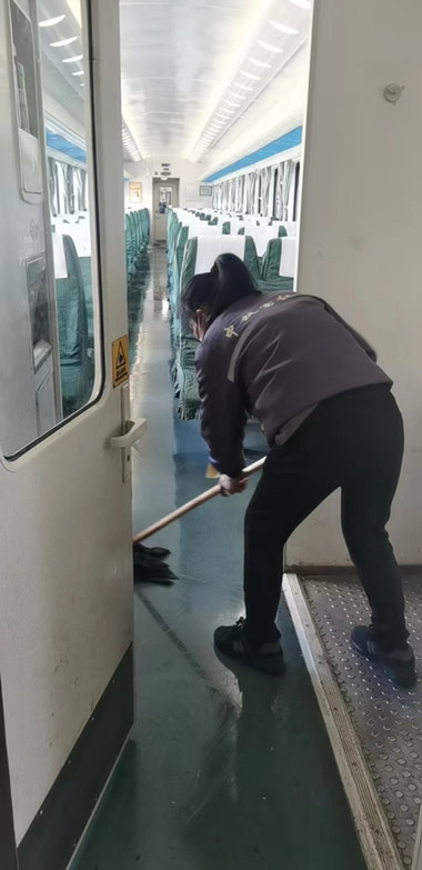 保洁人员进行普速列车卫生清扫。伍洲 摄