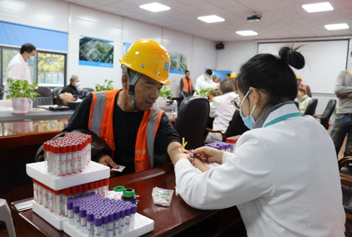 医护人员给工友进行体检。受访单位供图