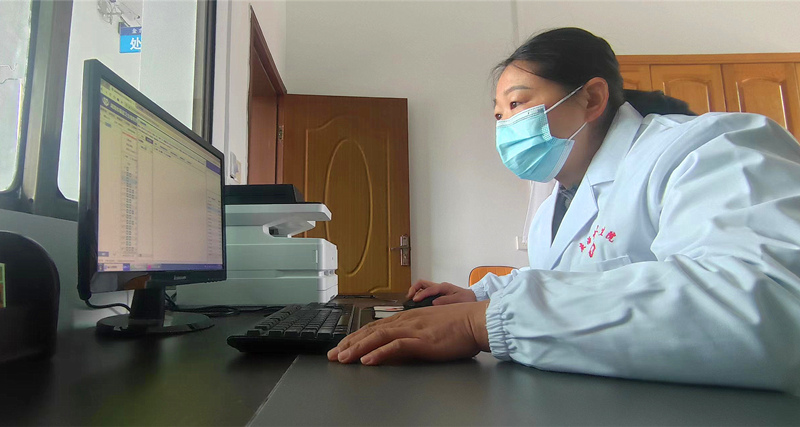 文喜在电脑上查看村民的健康档案。人民网记者 刘宾摄
