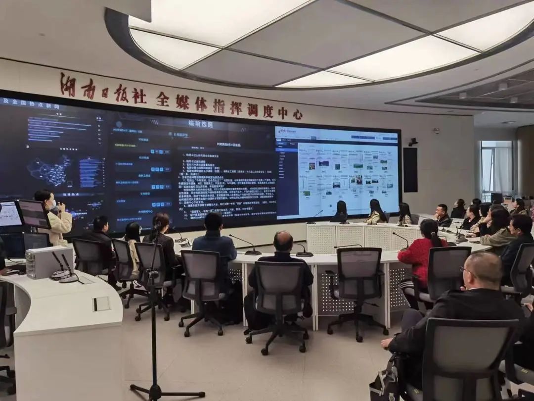 与会人员在湖南日报社全媒体指挥调度中心参观了解新闻生产流程。洪志摄