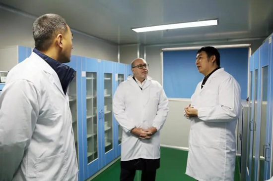 王輝(右一)向海外客戶介紹國家輔料工程中心情況。受訪單位供圖