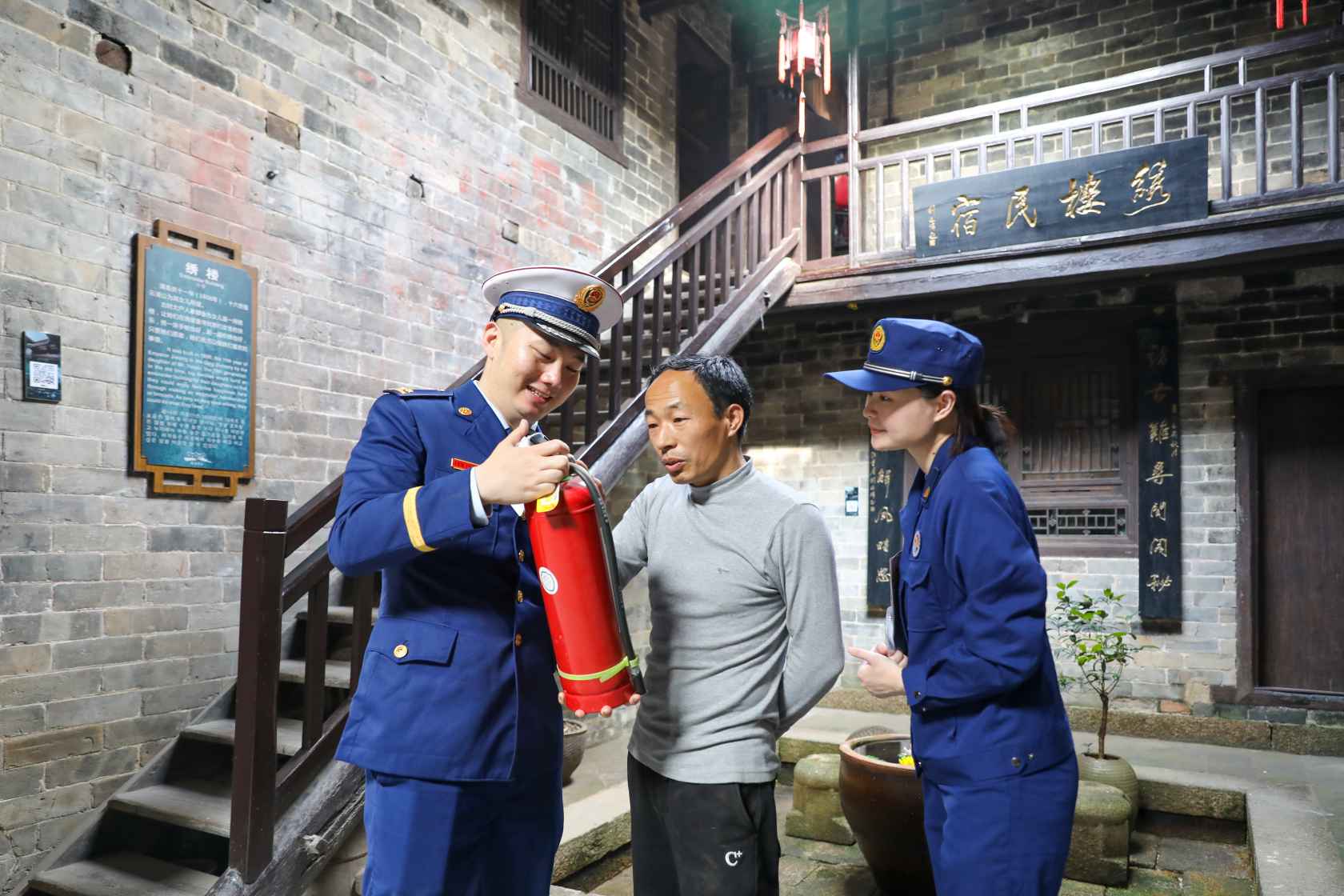 消防宣传人员为村民讲解灭火器如何操作（单位供图）