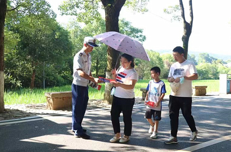 消防救援人员向景区游客发放消防安全知识宣传单。单位供图