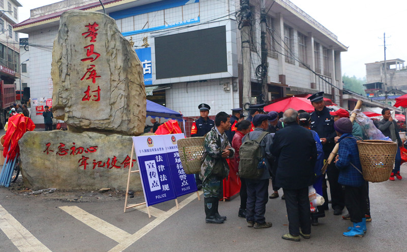 在集市上为群众解疑答惑。人民网记者 刘宾摄
