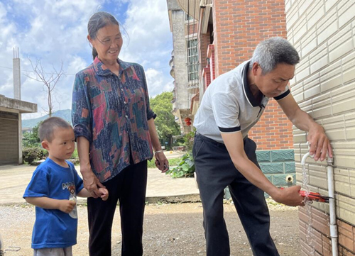 夏灣村“鄰先鋒”唐琨明在幫助村民修水管。陳健林攝