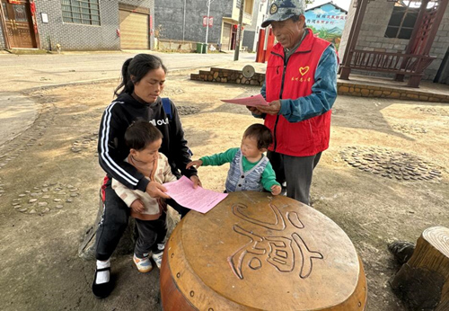 “村民代表”在村里给村民宣传政策。周文摄