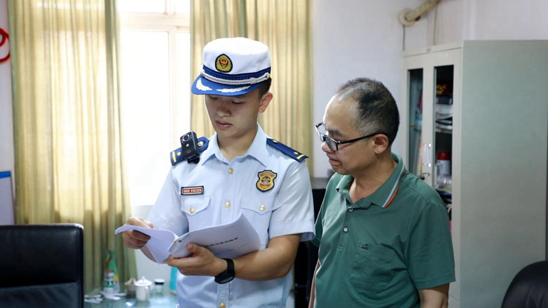 消防监督员查看消防器材检查记录。单位供图