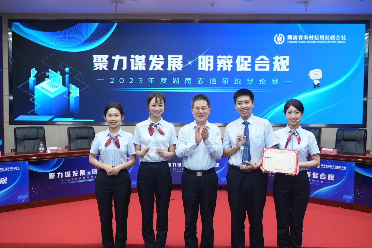 湖南省农信联社党委书记张世平为决赛获胜队长沙农商银行辩论队颁奖。单位供图