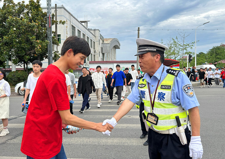 交警石彬与考生握手,送上祝福。林彬摄