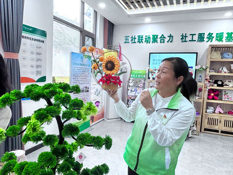 開慧社工站社工李柳英在介紹編織品。何彪攝