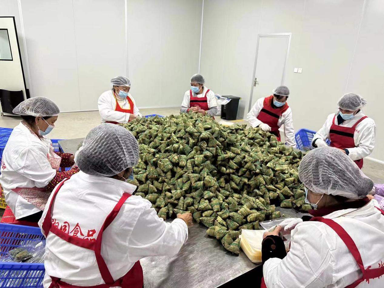 在和湘园食品厂内，工人们正加班加点赶制产品。单位供图