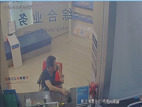 犯罪嫌疑人在柜台办理取款业务时坐立不安。企业供图