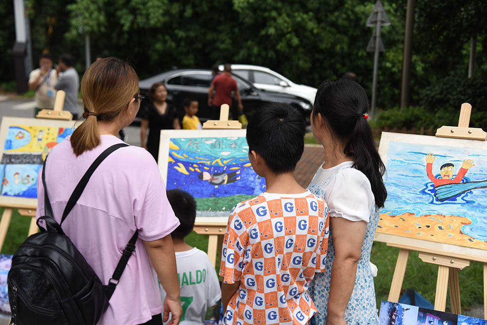 家長和孩子正在欣賞防溺水主題畫展。單位供圖
