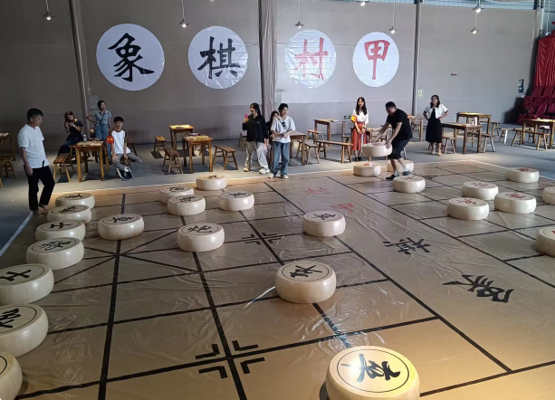 两位选手在超大棋盘上以巨型棋子对弈。主办方供图