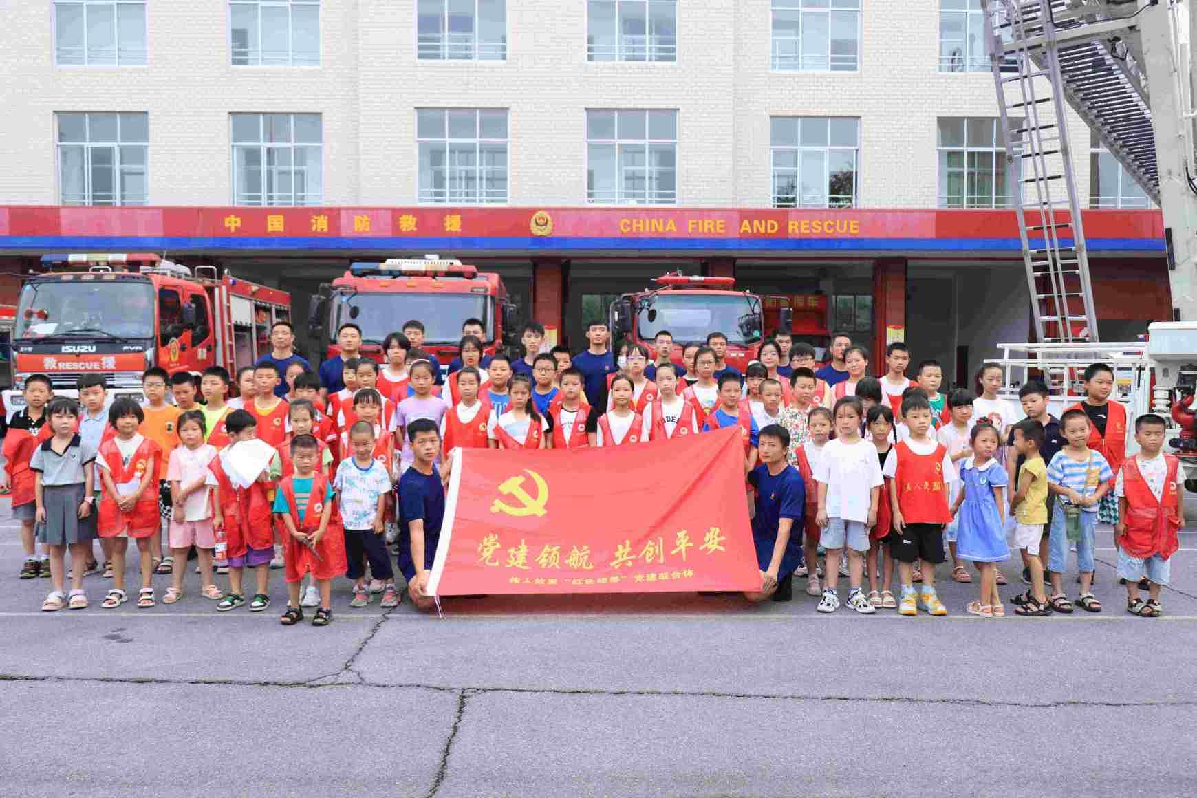 消防救援人员、映山红志愿者组织与孩子们合影留念。单位供图