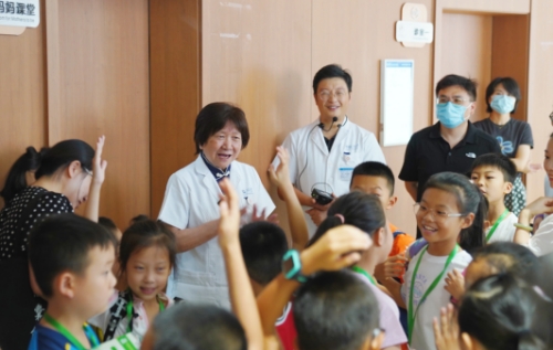 卢光琇与来医院参观的学生见面、打招呼。受访单位供图